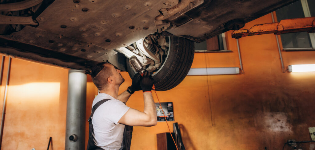 Frontline automotive worker inspecting a car on the factory floor